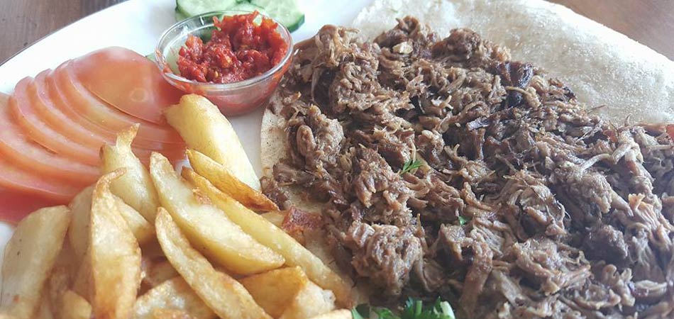 Pulled beef served in a flatbread with salad