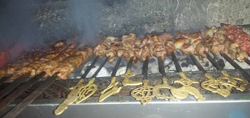Meat grilling on skewers on the white-hot coals